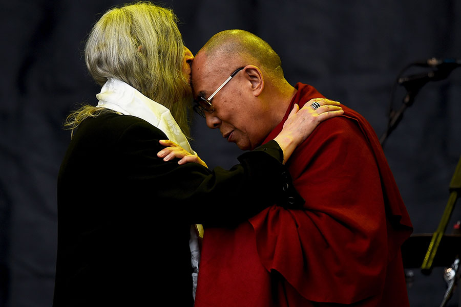 Patti Smith kisses the Dalai Lama as she performs on the Pyramid stage at Glastonbury Fest, 2015.